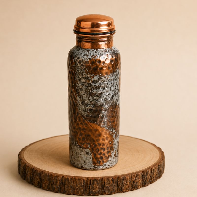 Botella artesanal de cobre puro con diseño texturizado y pátina de oxidación, ideal para regalo exclusivo de alta gama.