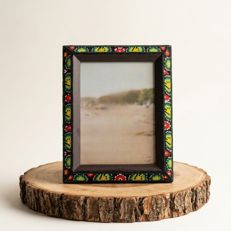 Marco de fotos artesanal con arte wixárika de flores violetas en chaquira, ideal para decoración mexicana de lujo.